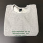 “This weather is so inconsistent, it’s giving men” embroidered sweatshirt
